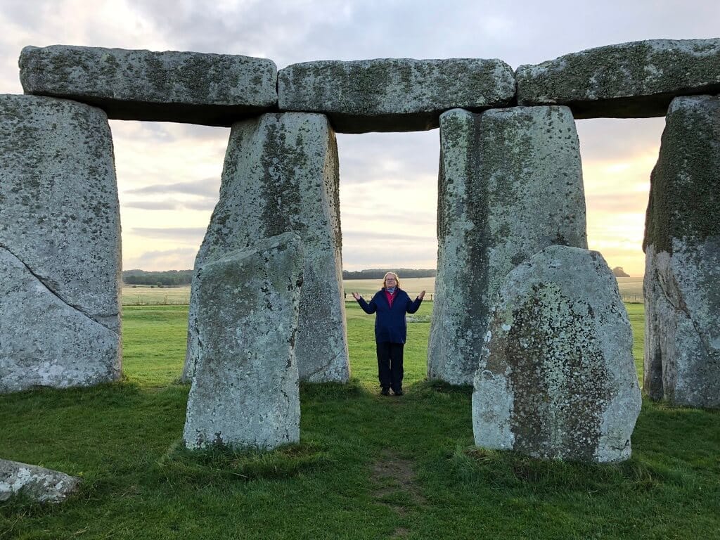 Person steht zwischen den Steinen von Stonehenge