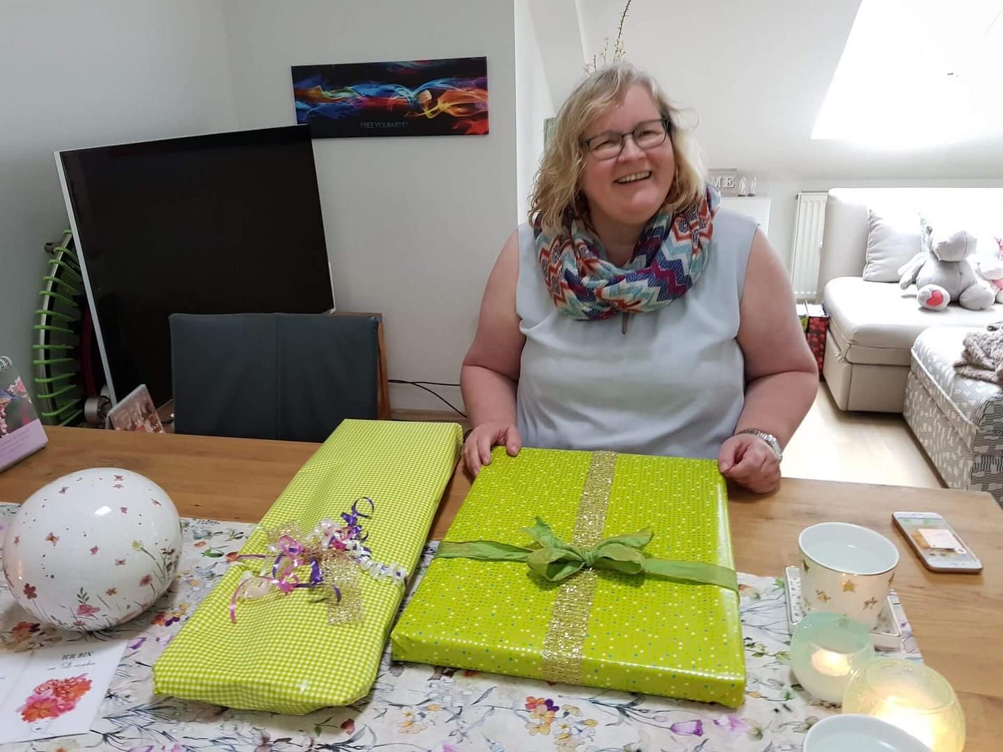 Frau lacht neben bunten Geschenkverpackungen