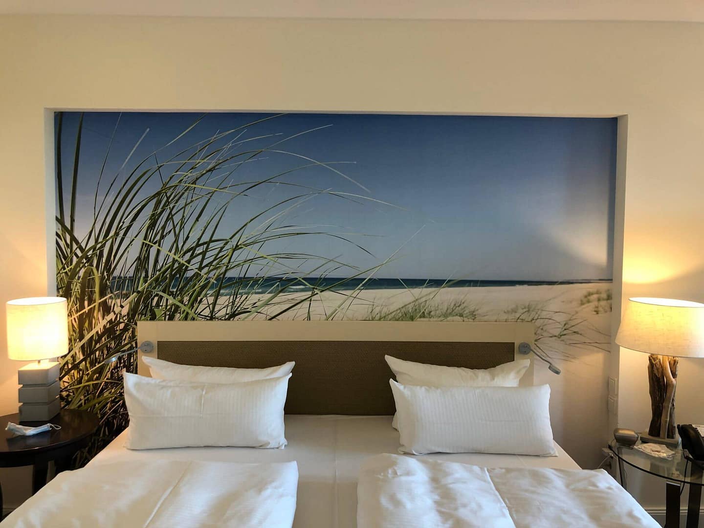 Schlafzimmer mit Strandblick-Wandbild und zwei Betten