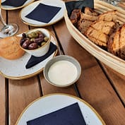 img_2493.jpg Brotkorb mit Oliven und Dips auf Holztisch