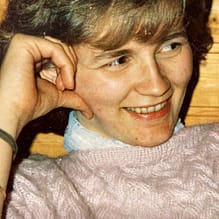 img 4848.jpg Lächelnde Frau in rosa Pullover lehnt Hand an Kopf