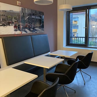 img_6102.jpg Moderne Cafeteria mit Tischen, Stühlen und großem Bild