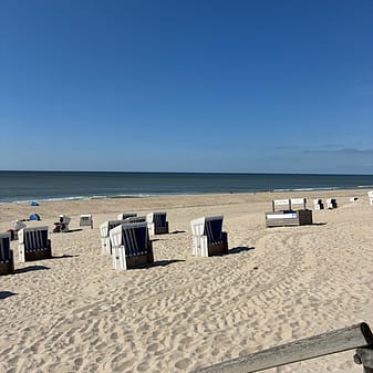 img 2025 05 18 125007 Strandkörbe am sonnigen Sandstrand mit blauem Himmel