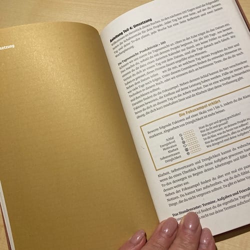 img_3259.jpg Offenes Buch mit deutschem Text auf Schreibtisch