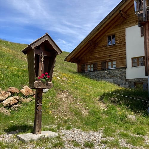 img 5217.jpg Wegkreuz neben Alpenhaus unter blauem Himmel