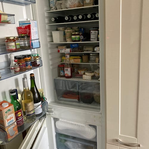 08037B8E-3A06-4816-A4A6-43EB5DFF18E7 Offener Kühlschrank voller Lebensmittel und Getränke