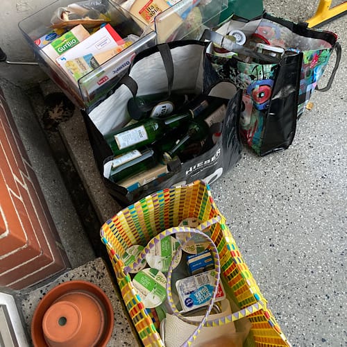 1DEA09ED-A12A-41BA-97E8-7267562811CA Taschen voller Recyclingmaterial auf Bürgersteig