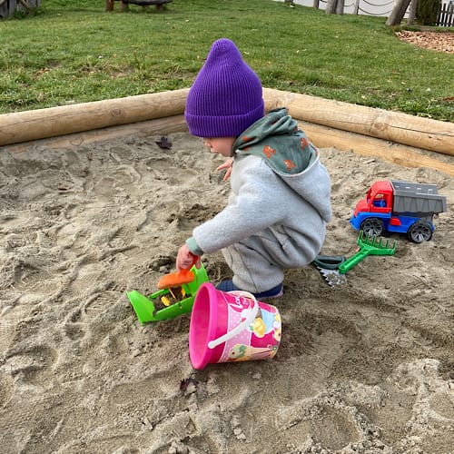 C941F78F-20B5-4F89-86C0-259133BCE07E Kind spielt mit Spielzeug im Sandkasten