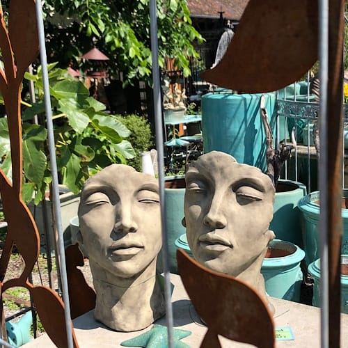 Kopfskulpturen in einem Garten