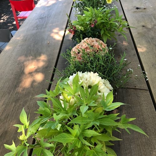 Blumenarrangement auf einem Holztisch im Freien