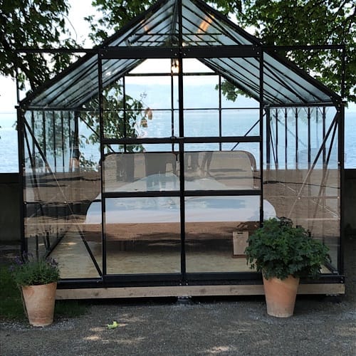 Gewächshaus mit Bett am Seeufer