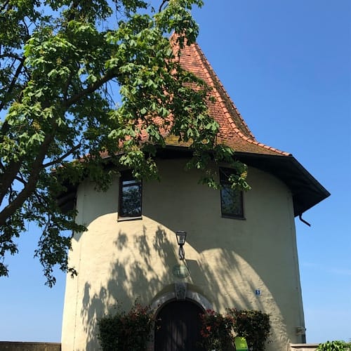 Historisches rundes Gebäude mit Ziegeldach und Bäumen