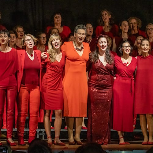 "Ladies First" Barbershop-Chor in rotem Bühnenoutfit bei ihrem Chorical-Auftritt "Lady in Red" in Dortmund