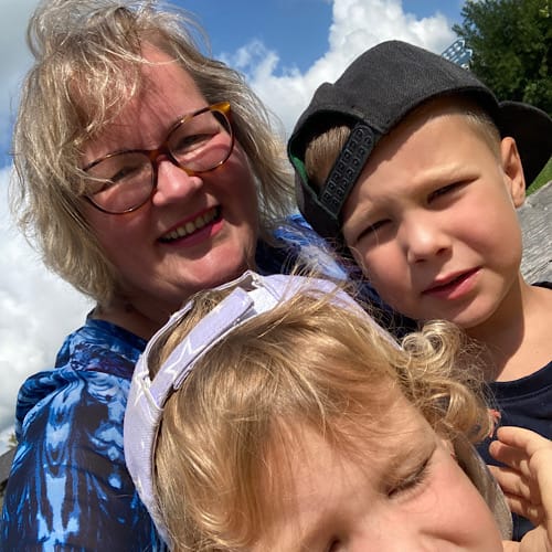 Birgit Nora Schäfer mit ihren Enkeln Noah und Emma bei Wind auf einem Spielplatz