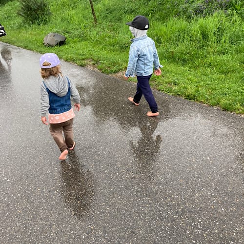Meine Enkel Noah und Emma tapsen barfuß durch den Regen