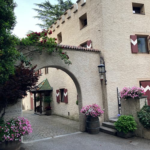 Idyllische Torbogeneinfahrt mit Blumen zum Weingut Schloß Plars, Algund, Südtirol
