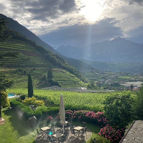 Sonniger Blick auf terrassierte Weinberge und Gartenterrasse beim Schloß Plars in Algund