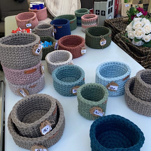 Handgehäkelte Körbe in verschiedenen Farben und Größen auf einem Marktstand ausgestellt beim Kunsthandwerkermarkt im Westfalenpark, Dortmund