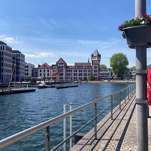 Hafenpromenade am Phönixsee mit Blick auf den kleinen Hafen mit Booten und das Gebäude der Hörder Burg in Dortmund