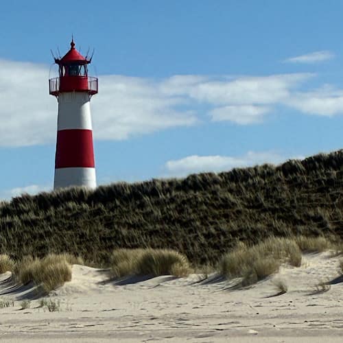 Leuchtturm auf Dünen auf dem Ellenbogen von List / Sylt unter blauem Himmel