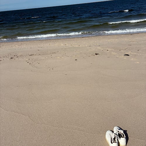 Weiße Schuhe am sonnigen Sandstrand am nördlichsten Punkt Deutschlands auf dem Ellenbogen bei List / Sylt