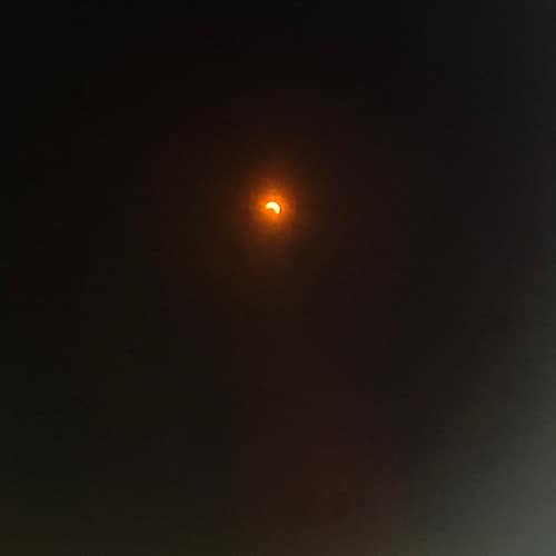 Partielle Sonnenfinsternis hinter dunklen Wolken