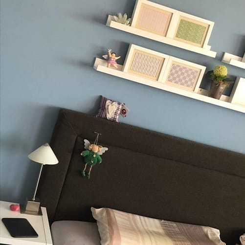 Gemütliches Schlafzimmer mit blauer Wand und Regalen