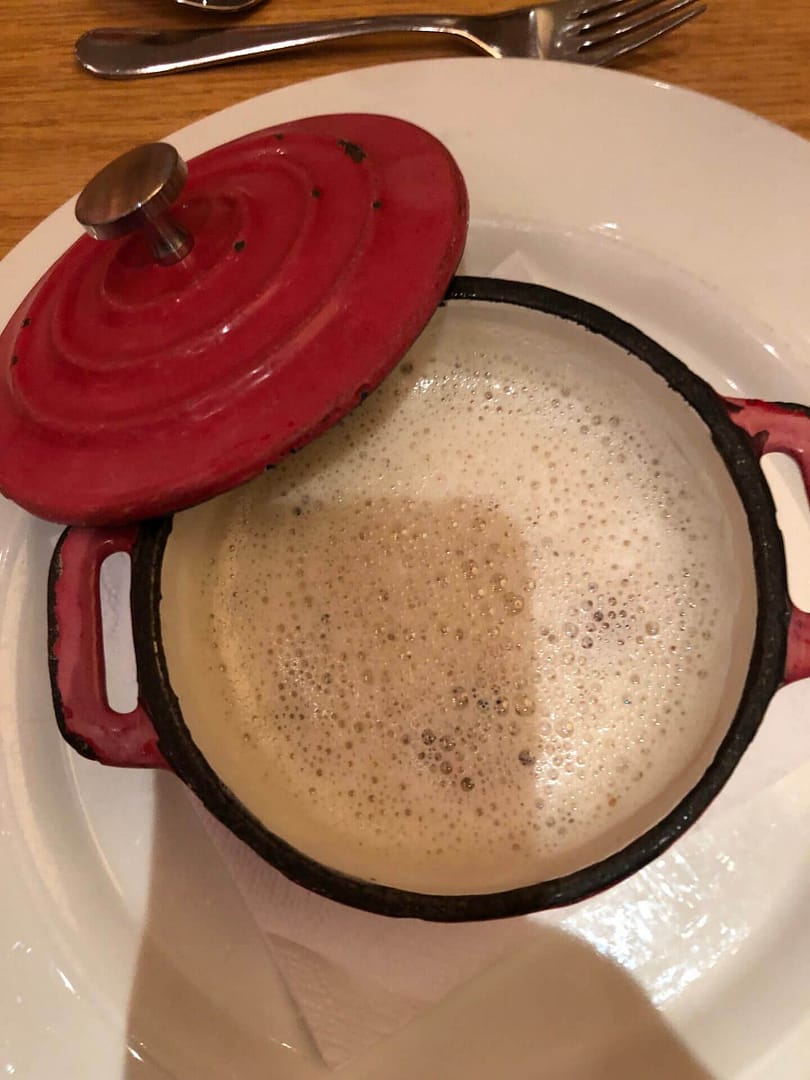 Heiße Suppe in roter Gusseisenpfanne