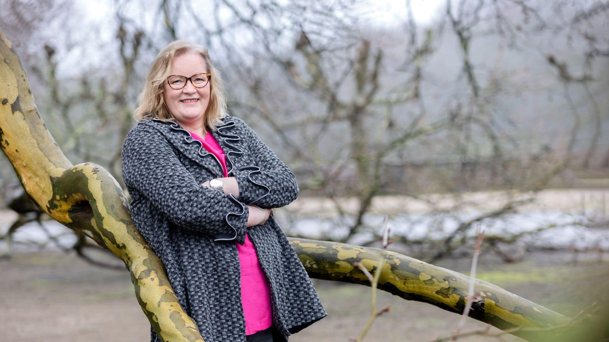 birgit nora schaefer angelehnt an einen baum mit verschraenkten armen 2000x1125